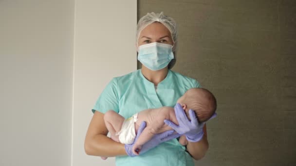 Female nurse holding a newborn baby in hospital. — Stock Video