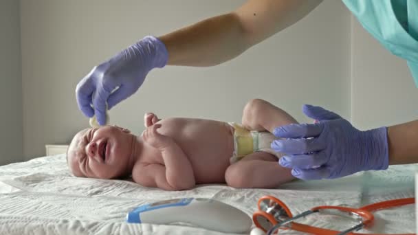 Νοσοκόμα σκουπίζει αξιολάτρευτο νεογέννητο πρόσωπο με μαντηλάκια καθαρισμού. Υγιεινή έννοια, καθαρό. — Αρχείο Βίντεο