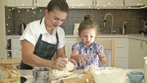 Charmante junge Frau und ihre 5-6 jährige Tochter kochen gemeinsam einen Teig. Angenehmer und lohnender Zeitvertreib. — Stockvideo