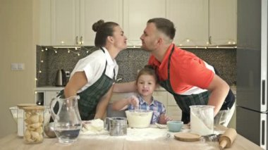 Üç kişilik neşeli aile mutfakta tatil için bir şeyler hazırlıyor. Herkesin keyfi yerinde..