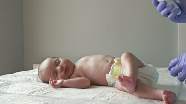 Misurare la temperatura di un neonato con un termometro senza contatto in una clinica. Primo piano. — Video Stock