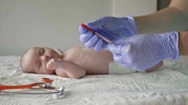 Pediyatrist, yeni doğan bebeği klinikte aşılıyor..