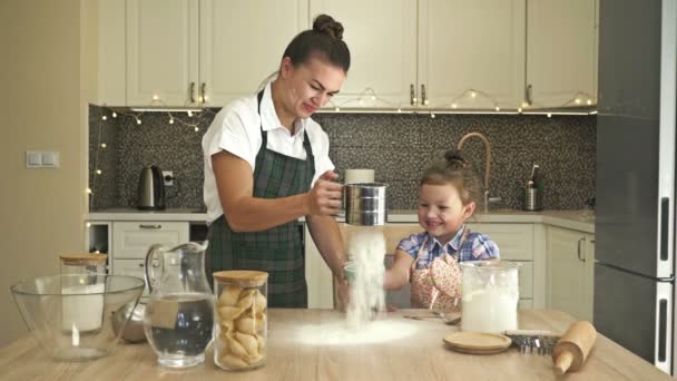 A filhinha ajuda a mãe a cozinhar alguma massa. Tempo de família divertido e gratificante. — Vídeo de Stock