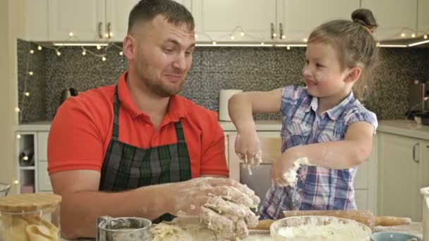 Munter ægtepar med en lille datter, tilberede nogle dej sammen, nyde familieaktiviteter. – Stock-video