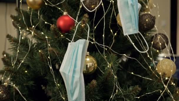 Medical masks on the Christmas tree. Christmas holidays in the new reality of Covid-19. Merry Christmas. — Stock Video