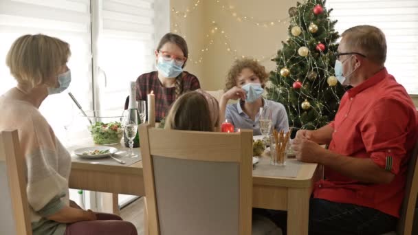 Familie viert Kerstmis met beschermende maskers. Coronavirusepidemie. Levensstijl COVID-19. — Stockvideo