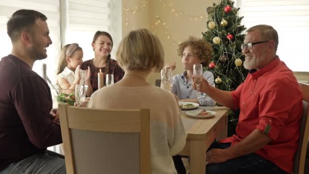 Wielka szczęśliwa rodzina świętująca Boże Narodzenie razem. Tradycyjna świąteczna kolacja w wielopokoleniowej rodzinie. — Wideo stockowe