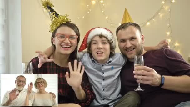 Giovane famiglia si congratula con i loro genitori anziani che vivono lontano, Buon Natale. Tecnologie moderne. Concetto di videochiamata familiare. — Video Stock