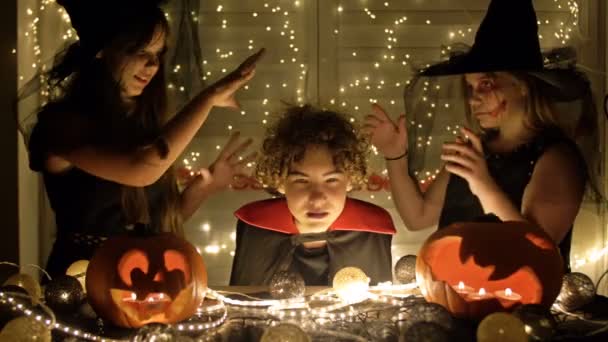 Halloween. Ragazzo e ragazze in costume giocano e si spaventano a vicenda di notte a casa. — Video Stock