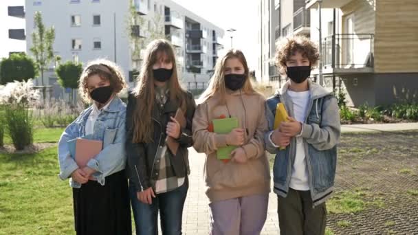 Koruyucu maskeler takan bir grup öğrenci. Koronavirüs salgınının yaşandığı akademik yıl. Okula geri dön.. — Stok video