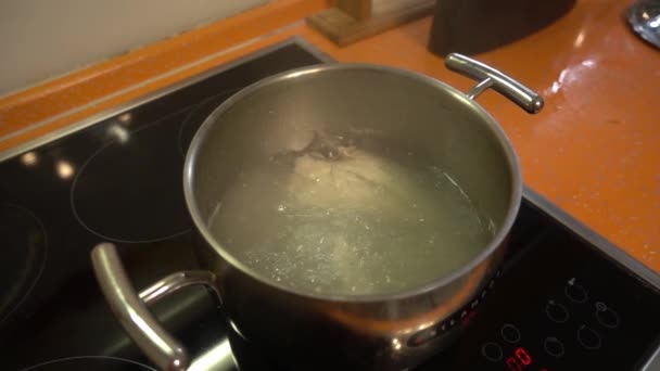 El agua hierve en una olla en la estufa en la cocina a cámara lenta — Vídeos de Stock