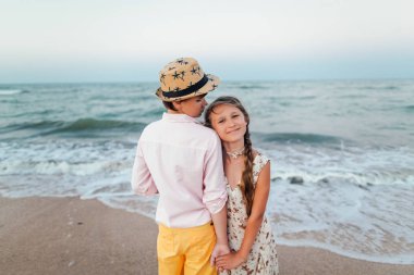 Çocuk oynamak ve eğlenmek sahilde. Sevgi dolu gençler. Deniz romantik hikaye. Çocuk kızla el ele tutuşsun. Retro tarzı