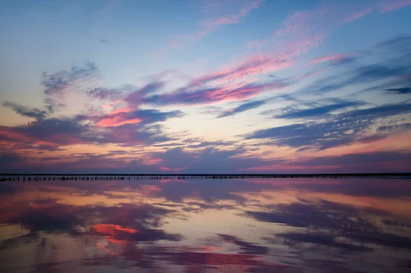 Sunset on the salt lake. Reflection of clouds in the water. Landscape