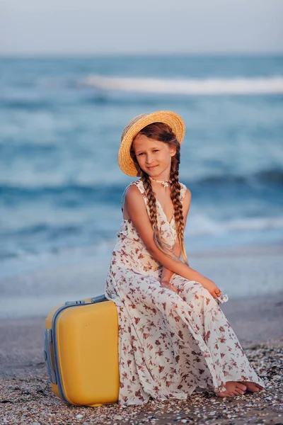 Küçük Bir Kız Plaj Sarı Bavula Oturur Şapkalı Bir Kız — Stok fotoğraf