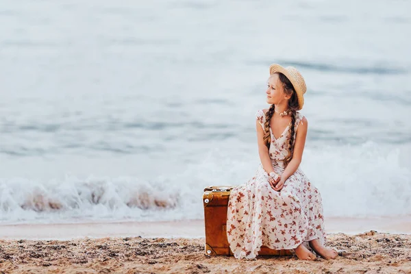 Küçük Bir Kız Plaj Sarı Bavula Oturur Şapkalı Bir Kız — Stok fotoğraf
