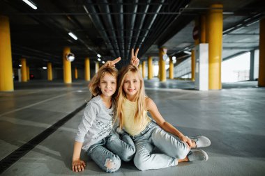 İki güzel kız kaykay, eğlenmek ve otoparkta oynarken. Sokak fotoğraf çekimi