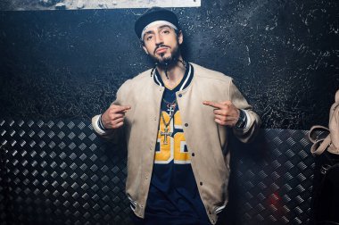 Gangsta rapçi demir kapı yakınında duruyor