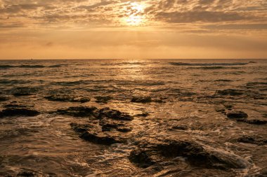 Deniz sahilinde portakal rengi gün batımı
