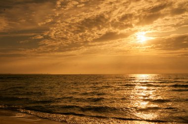 Deniz sahilinde portakal rengi gün batımı