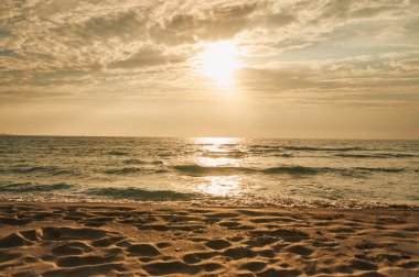 Deniz sahilinde portakal rengi gün batımı