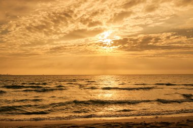 Deniz sahilinde portakal rengi gün batımı