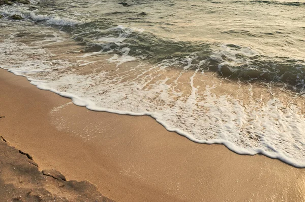 Küçük dalgalar. Deniz sahilinde portakal rengi gün batımı.