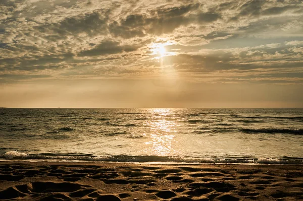 Deniz sahilinde portakal rengi gün batımı