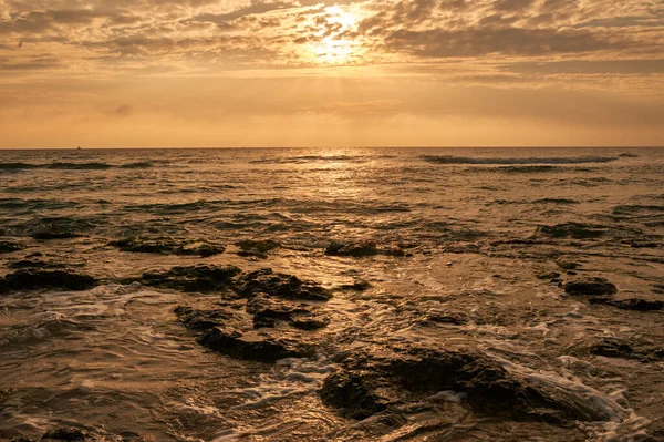 Deniz sahilinde portakal rengi gün batımı