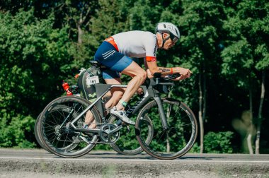 Kharkiv, Ukrayna - 11 Ağustos 2019: Bisiklet yarışması. Triatloncu, güneşli bir günde triatlon yarışmasında yüksek hızda at sürüyor.