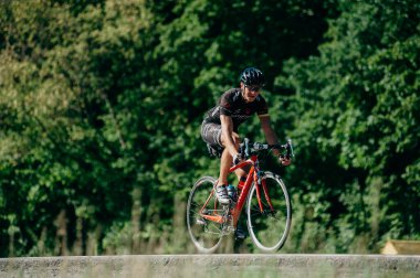 Kharkiv, Ukrayna - 11 Ağustos 2019: Bisiklet yarışması. Triatloncu, güneşli bir günde triatlon yarışmasında yüksek hızda at sürüyor.