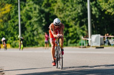 Kharkiv, Ukrayna - 11 Ağustos 2019: Triatlon. Triatlon bisikletli adam triatlon yarışında son sürat bisiklet sürüyor..