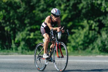 Kharkiv, Ukrayna - 11 Ağustos 2019: Triatlon. Triatlon bisikletli adam triatlon yarışında son sürat bisiklet sürüyor..