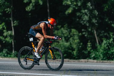 Kharkiv, Ukrayna - 11 Ağustos 2019: Triatlon. Triatlon bisikletli adam triatlon yarışında son sürat bisiklet sürüyor..