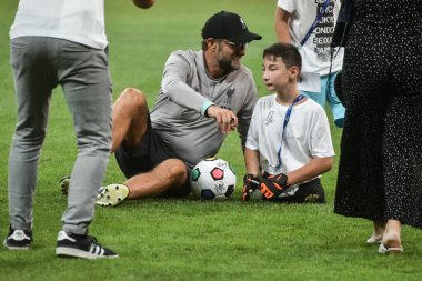 İstanbul, Türkiye - 13 Ağustos 2019: Liverpool FC teknik direktörü Jurgen Klopp UEFA Süper Kupası 'ndan önceki maç öncesi antrenmanında oğlanla sahada.