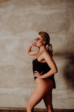 Rock konsepti. Siyah takım elbiseli ve deri ceketli çekici sarışın kadın portresi. Pembe güneş gözlükleri. 