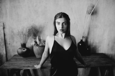 Çatı katındaki esmer kadının siyah beyaz portresi.