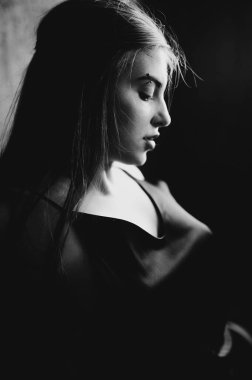 Çatı katındaki esmer kadının siyah beyaz portresi.