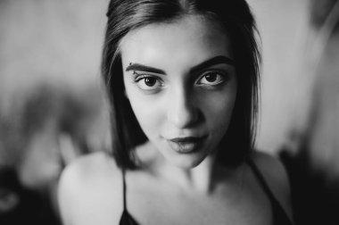 Çatı katındaki esmer kadının siyah beyaz portresi.