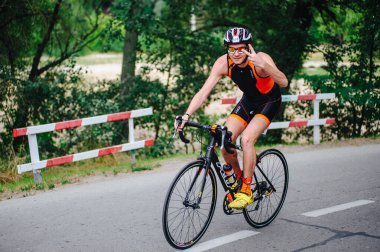 KHARKIV, UKRAINE - 2 Ağustos 2020 Demir Adam yarışması sırasında triatoncu bisikletli triatloncu bisikleti. Üç takım elbiseli ve kasklı bir bisiklet sporcusu. Halka açık etkinliklere izin var. CV salgını sırasında Avrupa sporu.
