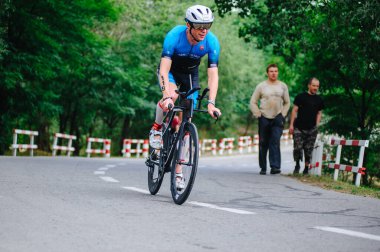 KHARKIV, UKRAINE - 2 Ağustos 2020 Demir Adam yarışması sırasında triatoncu bisikletli triatloncu bisikleti. Üç takım elbiseli ve kasklı bir bisiklet sporcusu. Halka açık etkinliklere izin var. CV salgını sırasında Avrupa sporu.