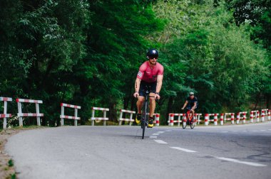 KHARKIV, UKRAINE - 2 Ağustos 2020 Demir Adam yarışması sırasında triatoncu bisikletli triatloncu bisikleti. Üç takım elbiseli ve kasklı bir bisiklet sporcusu. Halka açık etkinliklere izin var. CV salgını sırasında Avrupa sporu.
