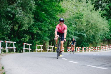 KHARKIV, UKRAINE - 2 Ağustos 2020 Demir Adam yarışması sırasında triatoncu bisikletli triatloncu bisikleti. Üç takım elbiseli ve kasklı bir bisiklet sporcusu. Halka açık etkinliklere izin var. CV salgını sırasında Avrupa sporu.