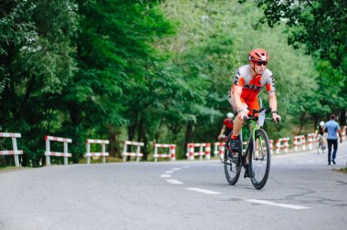 KHARKIV, UKRAINE - 2 Ağustos 2020 Demir Adam yarışması sırasında triatoncu bisikletli triatloncu bisikleti. Üç takım elbiseli ve kasklı bir bisiklet sporcusu. Halka açık etkinliklere izin var. CV salgını sırasında Avrupa sporu.