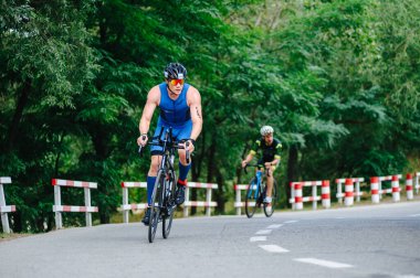 KHARKIV, UKRAINE - 2 Ağustos 2020 Demir Adam yarışması sırasında triatoncu bisikletli triatloncu bisikleti. Üç takım elbiseli ve kasklı bir bisiklet sporcusu. Halka açık etkinliklere izin var. CV salgını sırasında Avrupa sporu.