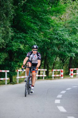 KHARKIV, UKRAINE - 2 Ağustos 2020 Demir Adam yarışması sırasında triatoncu bisikletli triatloncu bisikleti. Üç takım elbiseli ve kasklı bir bisiklet sporcusu. Halka açık etkinliklere izin var. CV salgını sırasında Avrupa sporu.