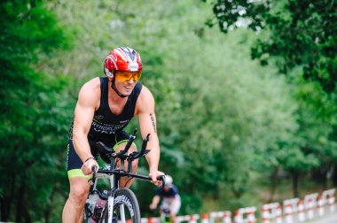 KHARKIV, UKRAINE - 2 Ağustos 2020 Demir Adam yarışması sırasında triatoncu bisikletli triatloncu bisikleti. Üç takım elbiseli ve kasklı bir bisiklet sporcusu. Halka açık etkinliklere izin var. CV salgını sırasında Avrupa sporu.