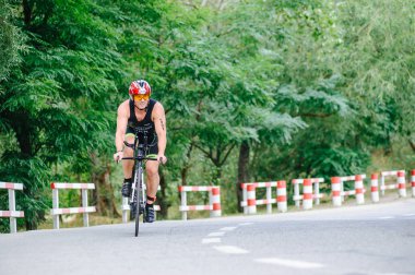 KHARKIV, UKRAINE - 2 Ağustos 2020 Demir Adam yarışması sırasında triatoncu bisikletli triatloncu bisikleti. Üç takım elbiseli ve kasklı bir bisiklet sporcusu. Halka açık etkinliklere izin var. CV salgını sırasında Avrupa sporu.