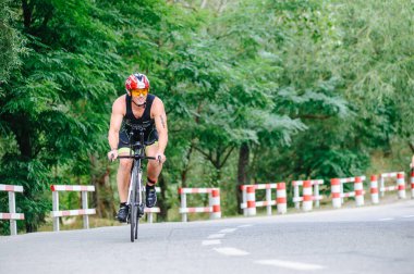 KHARKIV, UKRAINE - 2 Ağustos 2020 Demir Adam yarışması sırasında triatoncu bisikletli triatloncu bisikleti. Üç takım elbiseli ve kasklı bir bisiklet sporcusu. Halka açık etkinliklere izin var. CV salgını sırasında Avrupa sporu.