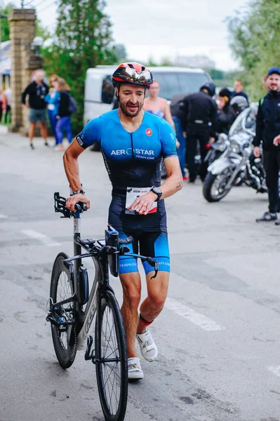 KHARKIV, UKRAINE - 2 Ağustos 2020 Demir Adam yarışması sırasında triatoncu bisikletli triatloncu bisikleti. Üç takım elbiseli ve kasklı bir bisiklet sporcusu. Halka açık etkinliklere izin var. CV salgını sırasında Avrupa sporu.