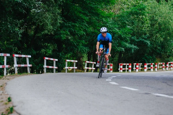 KHARKIV, UKRAINE - 2 Ağustos 2020 Demir Adam yarışması sırasında triatoncu bisikletli triatloncu bisikleti. Üç takım elbiseli ve kasklı bir bisiklet sporcusu. Halka açık etkinliklere izin var. CV salgını sırasında Avrupa sporu.